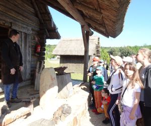 Uczniowie przed chatą kowala w Osadzie Średniowiecznej w Hucie Szklanej