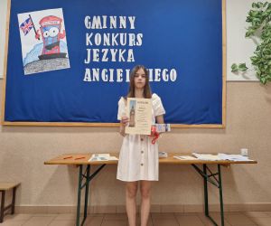 Uczennica klasy 8 prezentuje dyplom oraz nagrodę