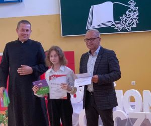 Uczennica w otoczeniu księdza i dyrektora szkoły