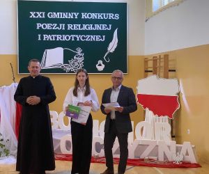 Uczennica w otoczeniu księdza i dyrektora szkoły