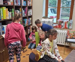 Uczniowie przy regałach z książkami