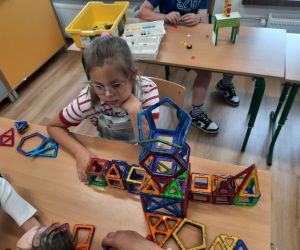 Uczennica buduje z klocków