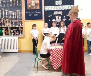 Uczennica składa podpis na karcie pasowania