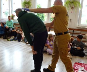 Strażak prezentuje sposób postępowania w przypadku zadławienia