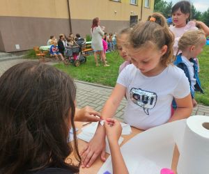 Uczennice przyklejają naklejki na paznokcie