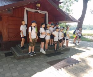 Uczniowie stoją przed kościołem w Szpikołosach