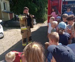 Strażak prezentuje strój strażacki 