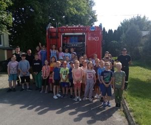 Uczniowie ze strażakami pozują do zdjęcia