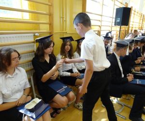 Uczeń klasy piątej wręcza drobny upominek uczennicy klasy ósmej