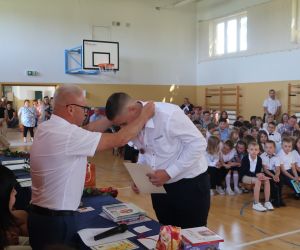 Dyrektor wręcza medal ósmoklasiście