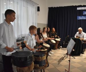 Na zdjęciu widoczna jest grupa muzyków grających na bębnach.