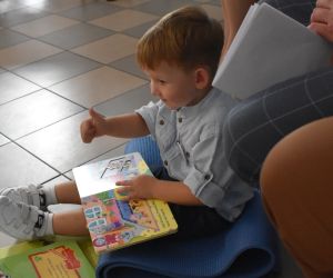 Na zdjęciu widoczne jest dziecko czytające książkę.