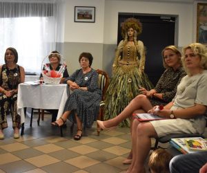 Na zdjęciu widać jest kilka osób siedzących na krzesłach.