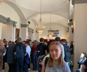 Uczennica na pierwszym planie w holu teatru, w tle uczniowie