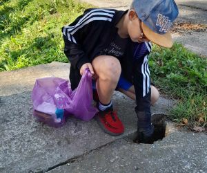 Uczeń zbiera śmieci do worka