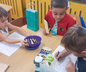 Dzieci kolorują przy stoliku.