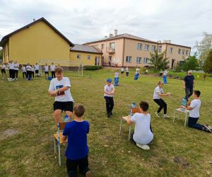Uczniowie klas starszych podczas wyścigu ze szklankami wypełnionymi wodą