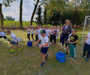 Uczniowie klas młodszych podczas wyścigu ze szklankami wypełnionymi wodą