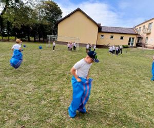 Uczniowie klas młodszych biorą udział w wyścigu w workach