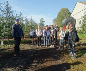 Uczniowie z właścicielem gospodarstwa w sadzie