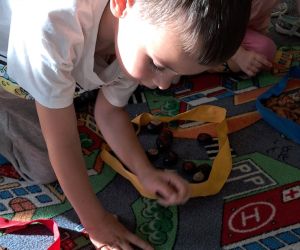 Dzieci dotykają dary jesieni.