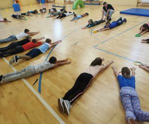 Dzieci wykonują ćwiczenia rozciągające 