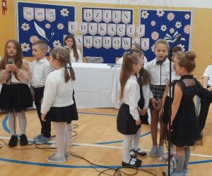 Uczniowie klasy pierwszej śpiewają przy mikrofonach