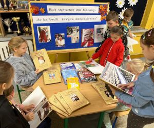 Uczniowie czytają książki o Janie Pawle II