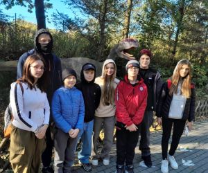 Uczniowie klasy szóstej na tle modelu dinozaura