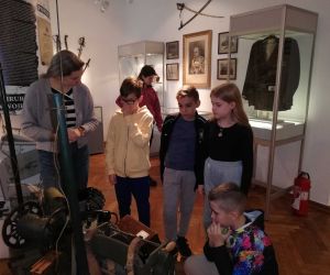 Uczniowie z przewodniczką przy eksponatach militarnych