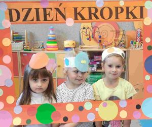 Trzy dziewczynki w strojach w kropki pozują w kropkowanej ramie okolicznościowej