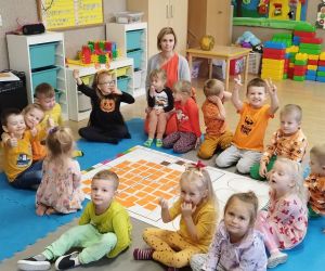 Przedszkolaki z wychowawczynią przy macie do kodowania