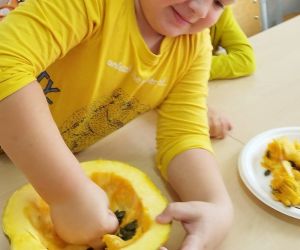 Chłopiec drąży dłonią dynię