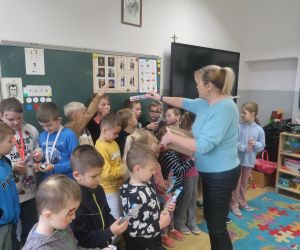 Pani rozdaje uczniom upominki