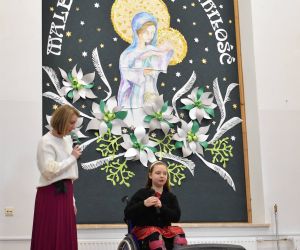 Kobieta i dziecko na scenie wewnątrz budynku.