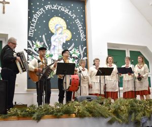 Zespół śpiewaczy z Instruktorem  wewnątrz budynku.