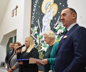 Grupa osób na scenie wewnątrz budynku. Odbiór statuetek, laureaci Konkursu.